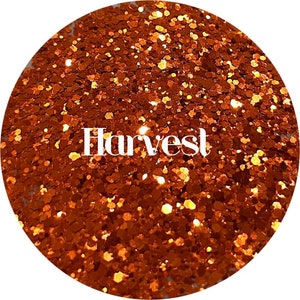 May include: A close-up of orange glitter with the word "Harvest" in white text.