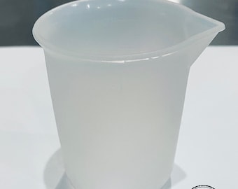 May include: A clear silicone mixing cup with a spout. The cup is designed for mixing and pouring liquids.