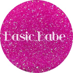 May include: A close-up of a bright pink glitter with a holographic finish. The glitter is in a circle and the text "Basic Babe" is in the center of the circle.