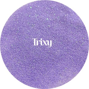 May include: A close-up of a circular object filled with lavender glitter. The word "Trixy" is written in white, centered on the object. The glitter has a sparkling effect, with small flecks of iridescent shimmer.