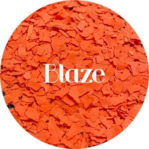Puede incluir: Primer plano de un mont&oacute;n de copos de color naranja, con la palabra "Blaze" impresa en blanco en el centro.