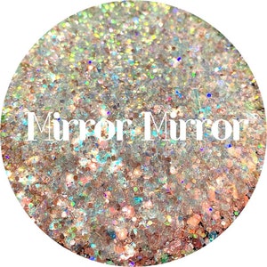 May include: Close-up of a circular arrangement of iridescent glitter. The glitter is a mix of silver, gold, and holographic colors. The text "Mirror Mirror" is displayed in white, centered on the image. The glitter is scattered throughout the image.