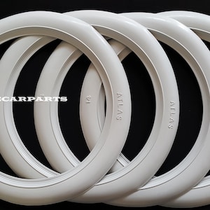 May include: Four white Atlas tire rings are stacked against a black background. The word "ATLAS" is embossed on the side of each ring. The text "EUROPECARPARTS" is visible in the upper left corner.