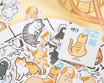 May include: A sheet of colorful stickers featuring cartoon cats and dogs. The stickers are on a white background and have a variety of poses and expressions. The stickers are packaged in a small box with the text "Candy Stickers" and "Original Sticker" printed on it.