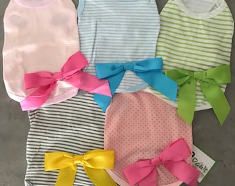 Puede incluir: Surtido de camisetas para perros en varios colores y estampados, incluyendo rayas rosas, azules, verdes y grises, y lunares rosas. Cada camiseta tiene un lazo de satén a juego. Las camisetas están diseñadas para perros pequeños.