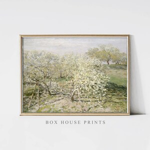 Puede incluir: Una pintura enmarcada de un paisaje con un campo de árboles en flor blanca. Los árboles están en primer plano y el fondo es un cielo azul brumoso.