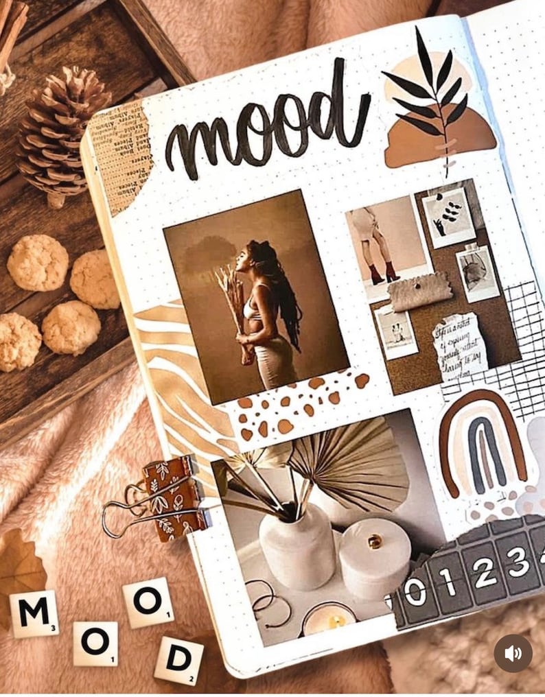 May include: A white page with the word "mood" written in black cursive. The page is decorated with brown, white, and black stickers, including a palm leaf, a rainbow, and a grid pattern. There are also several photos of people and objects, including a woman holding a branch, a vase with flowers, and a candle.