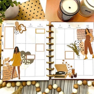 May include: A monthly planner with a September calendar page featuring a brown and white illustration of a woman, a record player, and a quote about growth. The planner has a gold ring binding and is decorated with brown and white polka dots.