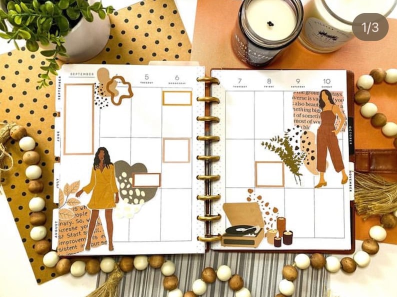 May include: A monthly planner with a September calendar page featuring a brown and white illustration of a woman, a record player, and a quote about growth. The planner has a gold ring binding and is decorated with brown and white polka dots.