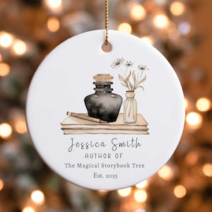 May include: White ceramic ornament with a watercolor illustration of a black ink bottle, a pencil, and a vase of flowers. The text reads "Jessica Smith, Author of The Magical Storybook Tree, Est. 2025".