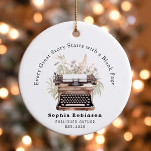 May include: White ceramic ornament with a vintage typewriter illustration and the text "Every Great Story Starts with a Blank Page". The ornament also includes the text "Sophia Robinson, Published Author, Est. 2025".