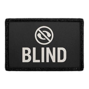 May include: A rectangular black patch with a stitched border. The design features a white circular icon of an eye crossed out by a diagonal line, positioned above the word BLIND in bold, white, sans-serif capital letters centered on the patch.