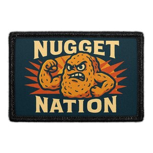 May include: A rectangular patch with the words "NUGGET NATION" in a bold, yellow font. The patch features an illustration of an angry, muscular chicken nugget with orange and yellow accents, set against a dark blue background with a black border.