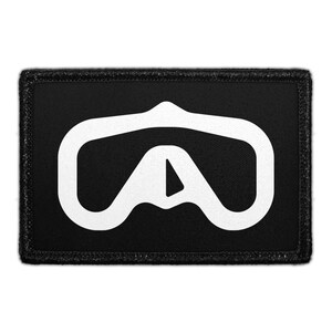 May include: A rectangular black patch featuring a white embroidered graphic design in the center. The design consists of a stylized, rounded, symmetrical shape that resembles a mask or a visor, with a triangular cutout at the bottom center.