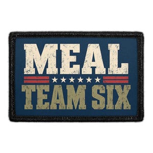 May include: A rectangular morale patch with a dark blue background and a black border. The text MEAL is in distressed white block letters above a row of six white stars and two red horizontal lines. The text TEAM SIX is in distressed tan.