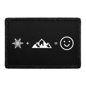 May include: A rectangular black patch featuring a white graphic equation. The design displays a snowflake symbol, a plus sign, a mountain range icon, an equals sign, and a smiling face icon arranged horizontally across the center of the patch.