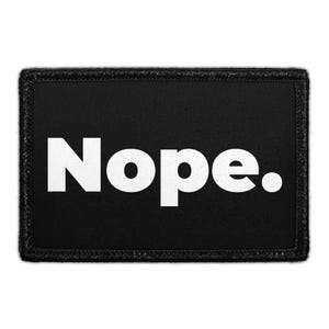 May include: A rectangular black patch with a stitched border featuring the word Nope. printed in bold white sans-serif capital letters across the center. The design is simple and high-contrast, with the text ending in a period.