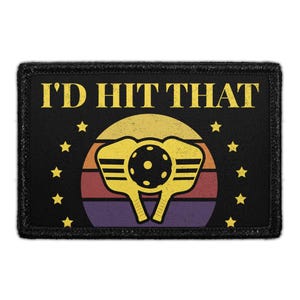 May include: Black patch with the text "I'D HIT THAT" in yellow, above a yellow pickleball and paddles design set against a sunset background. The design includes yellow stars around the edges.