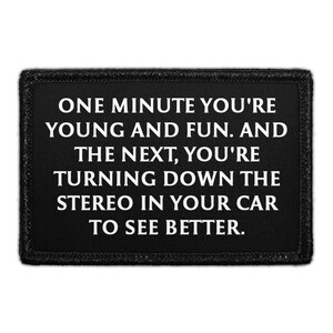 May include: A rectangular black patch with a stitched border featuring the white text: ONE MINUTE YOU'RE YOUNG AND FUN. AND THE NEXT, YOU'RE TURNING DOWN THE STEREO IN YOUR CAR TO SEE BETTER. The design is centered on a solid black fabric background.