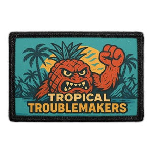May include: A rectangular embroidered patch with a black border featuring a graphic of an angry pineapple creature with a raised fist. The background shows palm trees and a yellow sun against a teal sky. The text TROPICAL TROUBLEMAKERS is printed below.