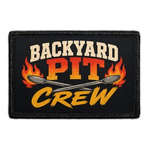 May include: A rectangular black patch featuring the text BACKYARD PIT CREW in bold, distressed lettering. The word BACKYARD is white, PIT is orange, and CREW is yellow. Two crossed metal grill tongs are centered with orange flames.