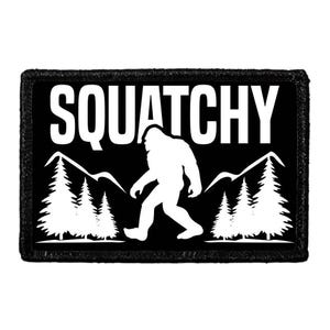 May include: A rectangular black patch featuring a white graphic of a Bigfoot silhouette walking between two groups of pine trees and mountain peaks. The word SQUATCHY is printed in large white capital letters across the top of the design.