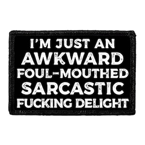 May include: A black rectangular patch with white text that reads: "I'M JUST AN AWKWARD FOUL-MOUTHED SARCASTIC FUCKING DELIGHT." The patch has a textured border.