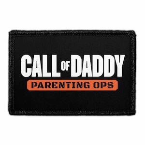 May include: A rectangular black embroidered patch with a stitched border. The text CALL OF DADDY is printed in large white capital letters. Below this, the text PARENTING OPS is printed in black capital letters inside an orange horizontal bar.