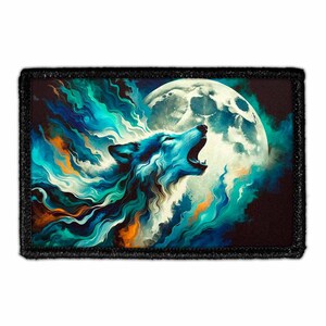 May include: A rectangular patch with a black border features a howling wolf against a full moon. The wolf is rendered in shades of blue, teal, and white, with the moon in the background. The artwork has a painterly style.
