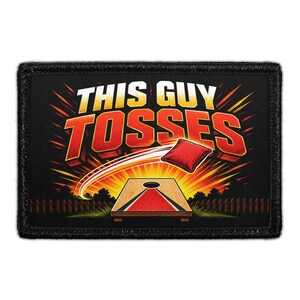 May include: A rectangular black patch featuring the text THIS GUY TOSSES in white and red letters. The graphic depicts a red bean bag flying through the air toward a wooden cornhole board with a red center stripe against a dark background.
