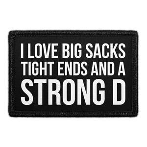 May include: A rectangular black patch with a stitched border featuring the white text I LOVE BIG SACKS TIGHT ENDS AND A STRONG D in a bold, sans-serif font. The design is centered on the black fabric background, creating a high-contrast appearance.