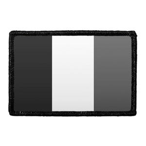 May include: A rectangular patch featuring a vertical tricolor design with a black left panel, a white center panel, and a dark gray right panel. The entire rectangular piece is bordered by a thick, textured black stitched edge.