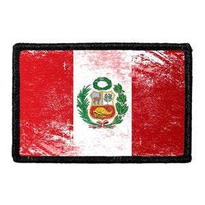 May include: A rectangular patch featuring the flag of Peru with a distressed, weathered texture. The design consists of two vertical red bands flanking a central white band, which displays the national coat of arms with a vicuña and cornucopia.