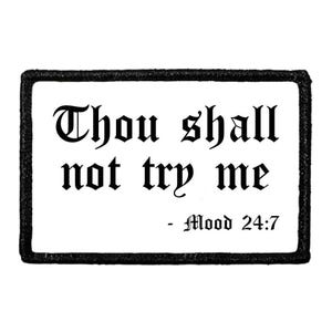 May include: A rectangular embroidered patch with a white background and a thick black border. The text reads "Thou shall not try me" in a black gothic-style font, followed by the text "- Mood 24:7" in the same black gothic typeface.