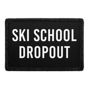 May include: A rectangular black patch with a stitched border featuring the white text "SKI SCHOOL DROPOUT" in a bold, sans-serif font. The design is centered on the black fabric background, creating a high-contrast look for this accessory.