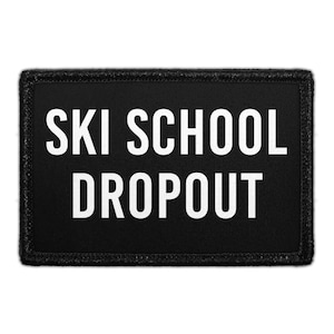 May include: A black rectangular patch with the words "SKI SCHOOL DROPOUT" in bold white letters. The patch has a black border and is likely designed to be sewn or ironed onto clothing or gear.