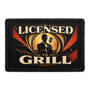 May include: A rectangular black patch featuring a central illustration of a person in a tuxedo holding a spatula. The text LICENSED TO GRILL is printed in cream-colored lettering. The background includes orange and red accents with a circular design.