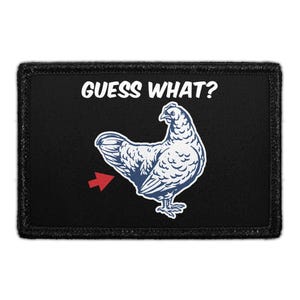 May include: Black patch with the text "GUESS WHAT?" above a blue and white chicken illustration. A red arrow points to the chicken's rear. The patch has a black border.