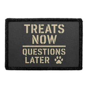 May include: A rectangular black patch with a stitched border featuring the beige text TREATS NOW QUESTIONS LATER in a stencil font, separated by a horizontal line, with a small beige paw print icon positioned after the final word.