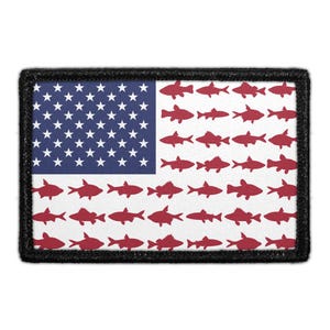 May include: A rectangular patch featuring a stylized American flag design. The blue canton contains white stars, while the stripes are replaced by rows of small, solid red fish silhouettes. The entire patch is bordered by a thick black stitched edge.
