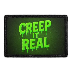 May include: A rectangular patch with the phrase "CREEP IT REAL" in dripping neon green letters on a dark green background. The patch has a black border.