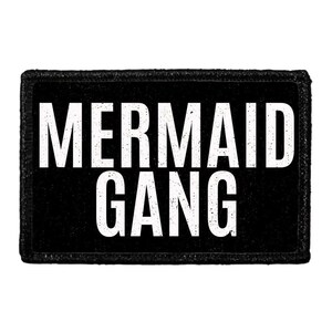May include: A rectangular black patch with the words "MERMAID GANG" in large, distressed white letters. The patch has a textured border.