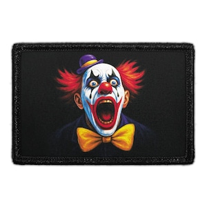 May include: A rectangular patch featuring a graphic illustration of a clown with bright red hair, a purple hat, and a yellow bowtie. The clown has white face paint, black eye markings, and a red nose, with an open mouth on a black background.