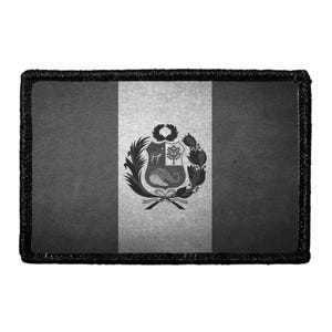 May include: A rectangular patch featuring a grayscale version of the Peruvian flag. The design consists of three vertical bands with a central coat of arms depicting a vicuña, a cinchona tree, and a cornucopia, all surrounded by a thick black border.