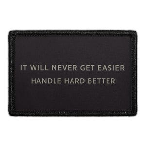 May include: A rectangular black patch with a stitched border featuring the gray text IT WILL NEVER GET EASIER HANDLE HARD BETTER centered on the surface. The design is clean and minimalist with a high-contrast color scheme for clear readability.