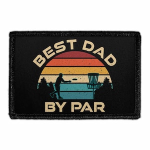 May include: A rectangular black patch featuring a retro-style sunset graphic in horizontal stripes of red, orange, yellow, and blue. The design includes a silhouette of a person throwing a disc toward a disc golf basket, with the text BEST DAD BY PAR.