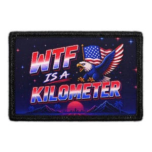 May include: A rectangular patch with a black border featuring pixel art of a bald eagle holding an American flag. The text reads "WTF IS A KILOMETER" in red, white, and blue gradient lettering against a dark starry sky with mountains and a sun.