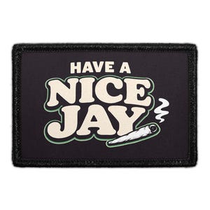May include: A rectangular black patch with a stitched border featuring the cream-colored text "HAVE A NICE JAY" in a bold, rounded font. Below the text is a graphic of a hand-rolled cigarette with a small wisp of white smoke rising from it.