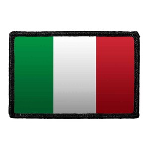 May include: A rectangular patch featuring the Italian flag with vertical stripes of green, white, and red. The design is enclosed by a thick, textured black border that frames the tricolor pattern, creating a distinct and defined edge for the item.