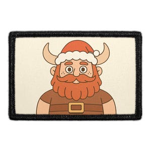 May include: A rectangular embroidered patch with a black border featuring a cartoon illustration of a bearded character wearing a Santa hat with horns. The character has a thick orange beard, a brown shirt with a belt, and a cream-colored background.